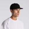 1119_SURF_COTTON_CAP_MAIN__46284 Man wearing a black baseball cap and white T-shirt, facing right against a light gray background.