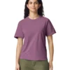 Woman wearing a mauve short-sleeve t-shirt and olive pants, facing the camera with a gentle smile.