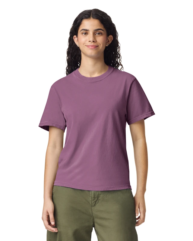 Woman wearing a mauve short-sleeve t-shirt and olive pants, facing the camera with a gentle smile.