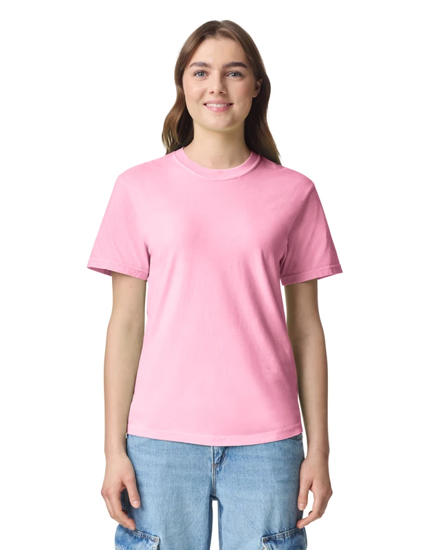 Woman wearing a pink short-sleeve T-shirt and light blue jeans, smiling at the camera against a white background.