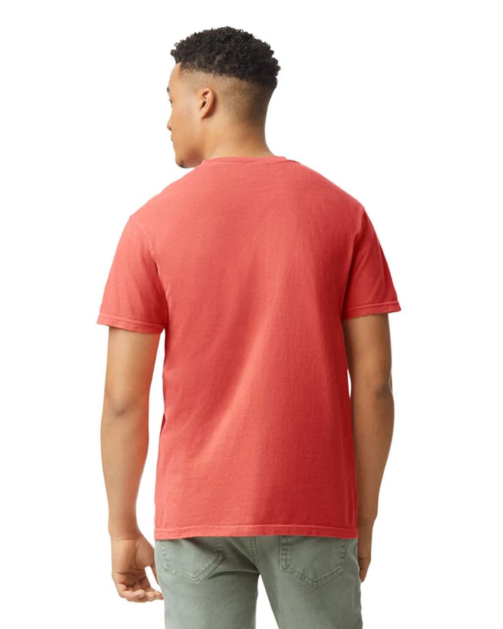 Back view of a man wearing a coral red short-sleeve T-shirt and olive-green jeans against a white background.