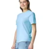 Young woman in a light blue T-shirt and denim jeans, standing slightly angled and smiling.