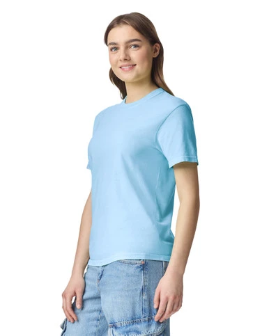 Young woman in a light blue T-shirt and denim jeans, standing slightly angled and smiling.