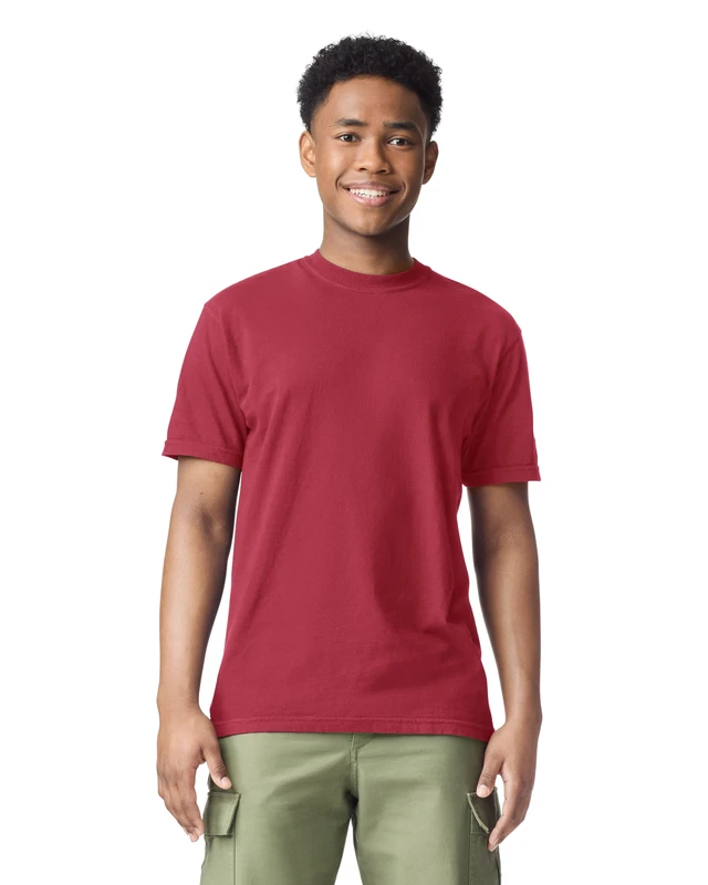 Young man with short curly hair smiling, wearing a red T-shirt and olive cargo shorts against a white background.