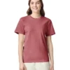 Smiling woman in a dusty rose short-sleeve T-shirt and light beige pants against a white background.
