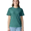 Woman wearing a teal crew-neck T-shirt and light blue jeans, smiling at the camera against a white background.