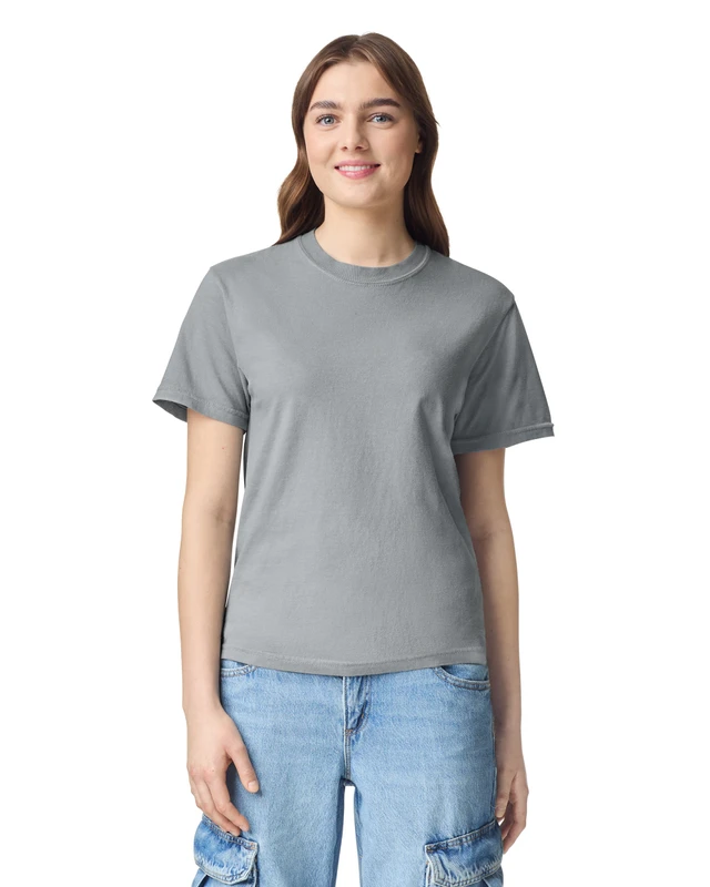 Woman wearing a plain gray crew-neck T-shirt and light blue jeans, smiling at the camera.