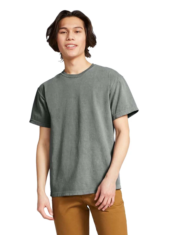 Young man wearing a gray short-sleeve T-shirt and tan pants, standing against a white background with a relaxed posture.