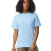 Woman wearing a light blue crew-neck T-shirt, standing against a white background.