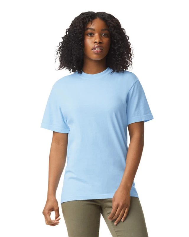 Woman wearing a light blue crew-neck T-shirt, standing against a white background.