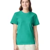 Woman wearing a green T-shirt and light beige pants, smiling at the camera against a white background.