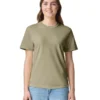 Young woman standing against a white background wearing an olive green t-shirt and light blue jeans, smiling.