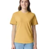 Young woman standing and smiling, wearing a mustard yellow T-shirt and light blue jeans against a white background.