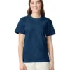 Woman wearing a navy blue crew-neck T-shirt, standing and smiling against a white background.
