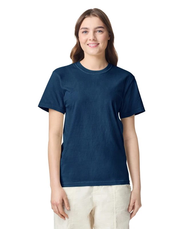 Woman wearing a navy blue crew-neck T-shirt, standing and smiling against a white background.