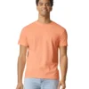 Smiling man wearing a peach T-shirt and light blue jeans, standing against a white background.