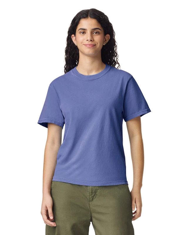 Front-facing woman in a plain blue crew-neck T-shirt and olive-green pants in a studio setting.