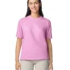 Woman wearing a light pink short-sleeve T-shirt, standing and smiling against a white background.