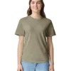 Young woman standing and smiling, wearing an olive green short-sleeve T-shirt and light blue jeans against a white background.