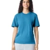 Woman standing and smiling in a blue crewneck T‑shirt and light gray shorts.