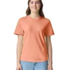 Woman in a peach short-sleeve T-shirt and light blue jeans, smiling at the camera.