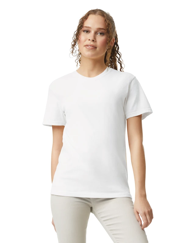 Woman wearing a plain white T-shirt and light beige pants, standing against a white backdrop in a studio setting.
