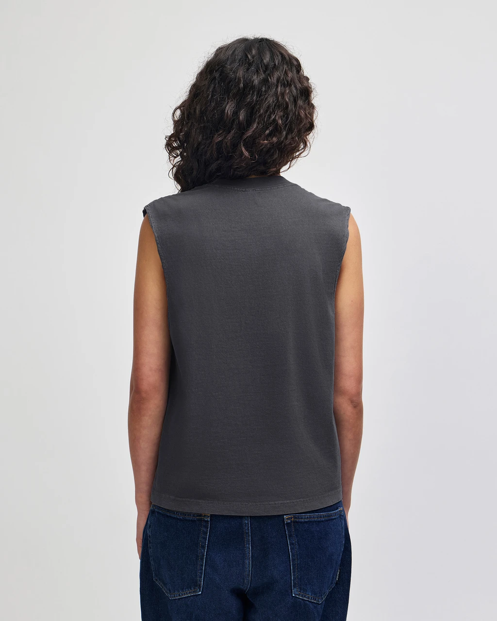 207GD_FadedBlack_03__17458 Person shown from behind wearing a dark gray sleeveless top and blue jeans.