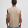 207GD_FadedBone_03__65348 Man seen from behind wearing a beige sleeveless shirt and blue jeans; tattoos on arms and neck visible.