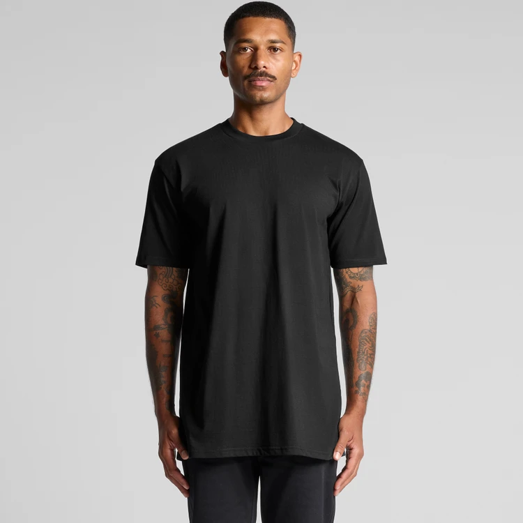 5070_CLASSIC_PLUS_TEE_MAIN__08942 Front view of a man wearing a plain black oversized T-shirt against a light gray background.
